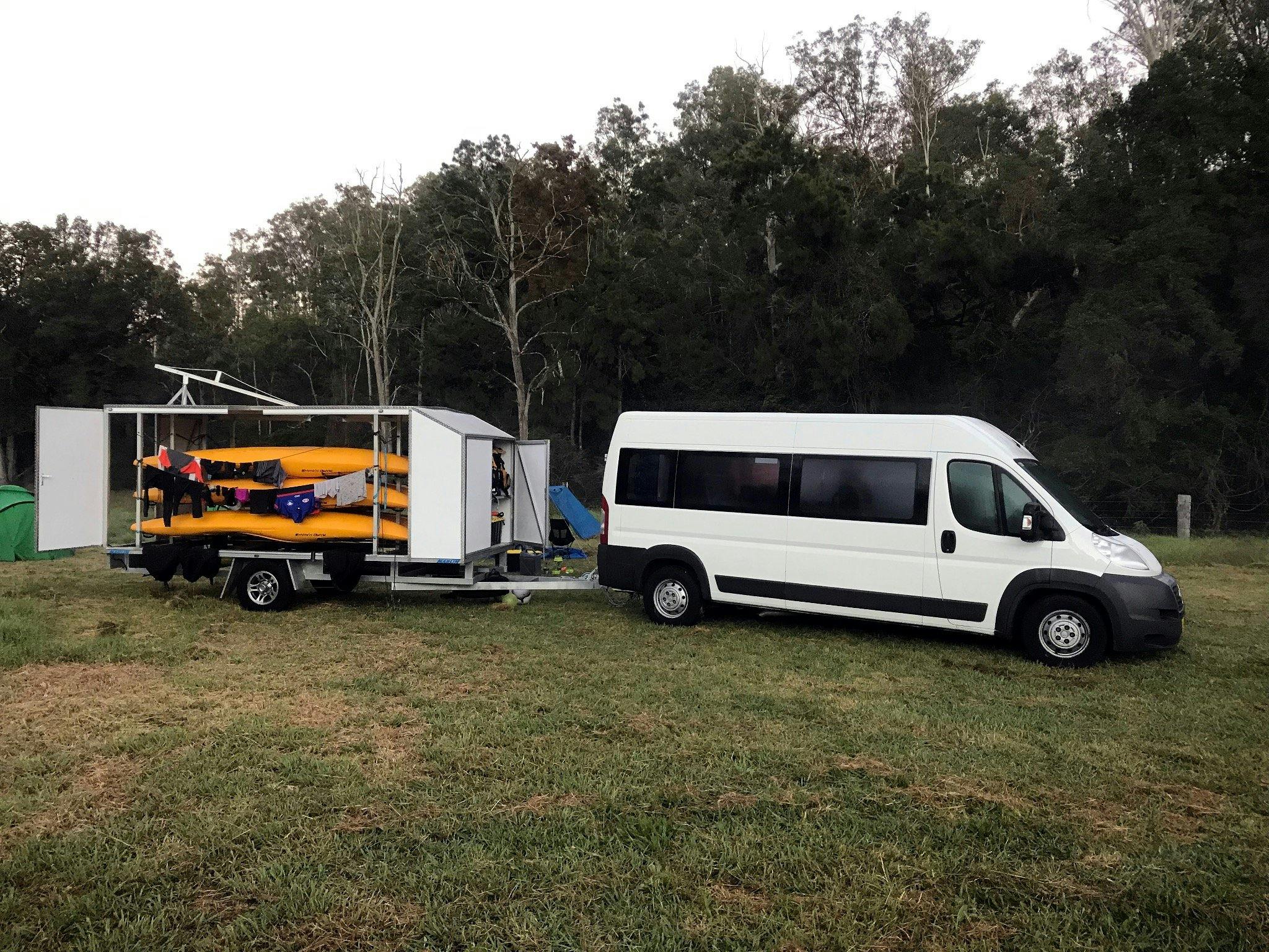 Walking Rivers bus and Kayak Trailer is parked at a campsite beside the Barrington River