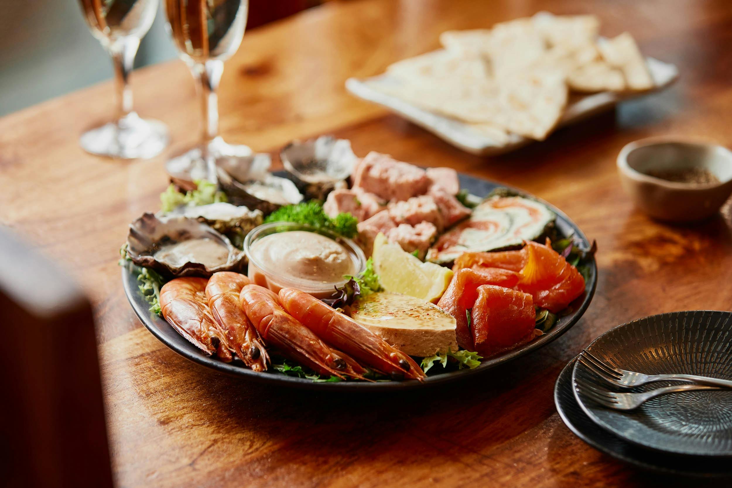 A bowl of mixed gourmet seafood, including smoked salmon, prawns, terrine, roulade, oysters and more