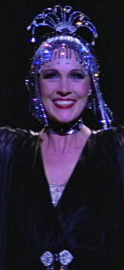 Woman performing with two men on either side wearing white hats