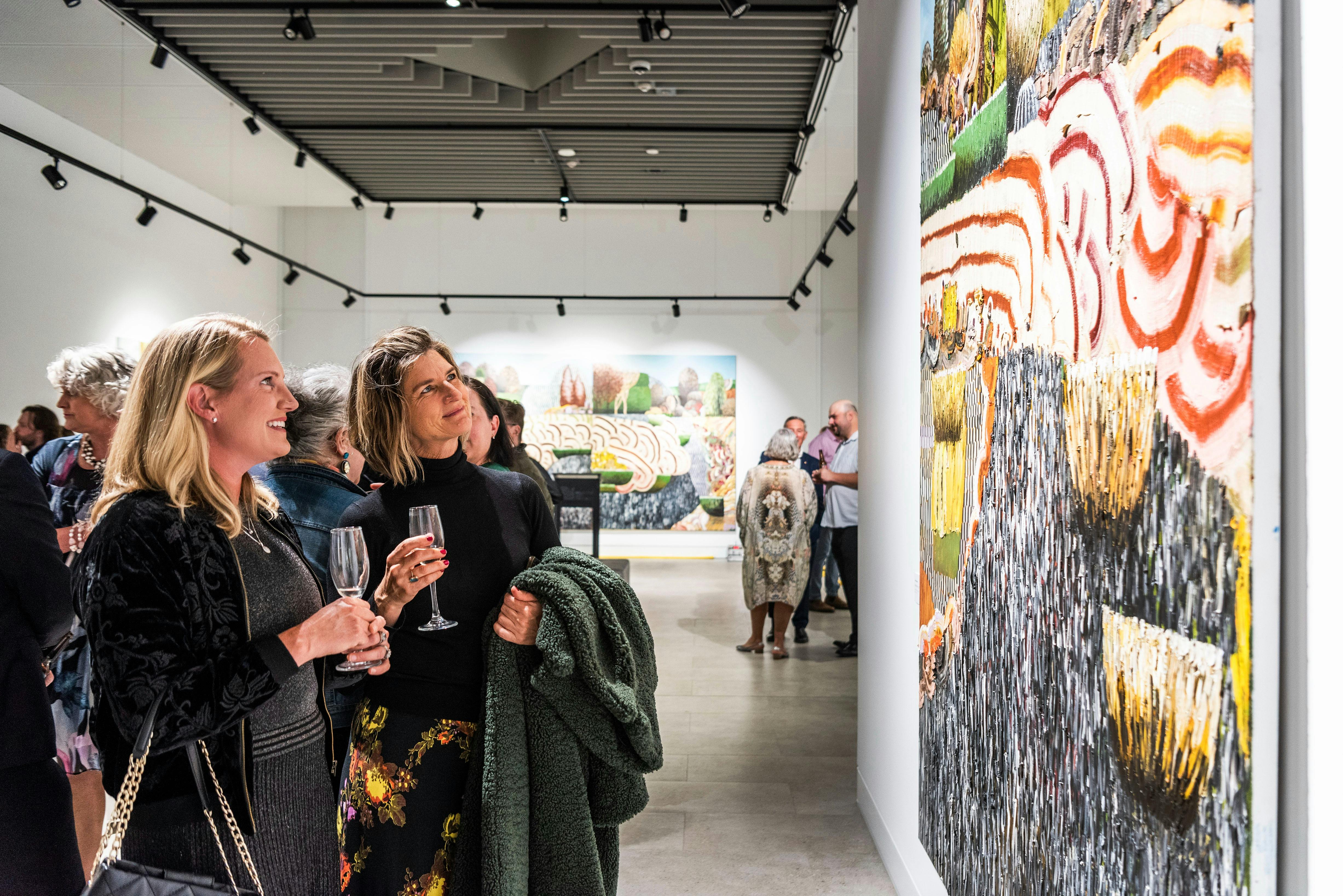 Visitors looking at a Guido Maestri painting at Mudgee Arts Precinct