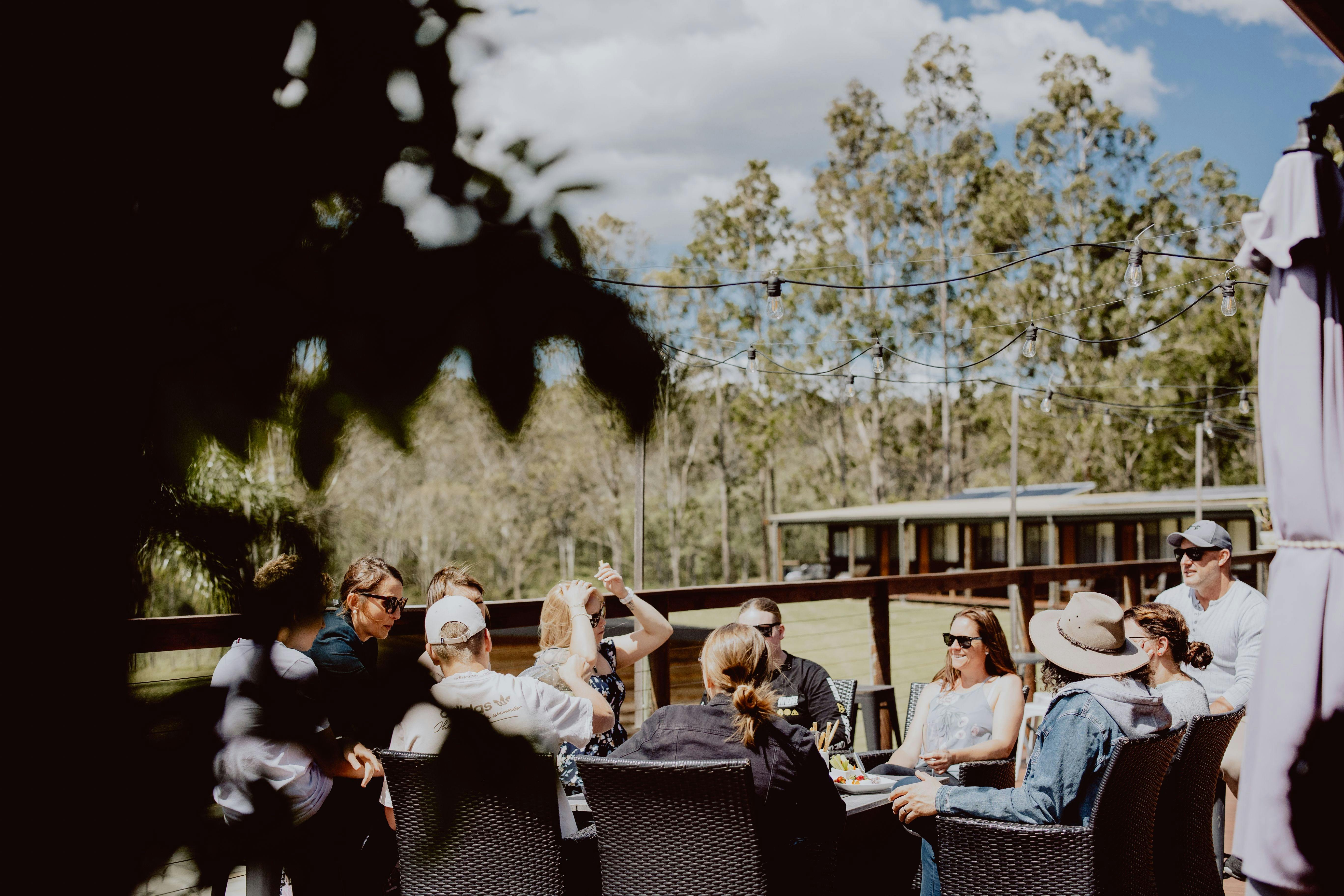 Group of people sitting around a table on a deck