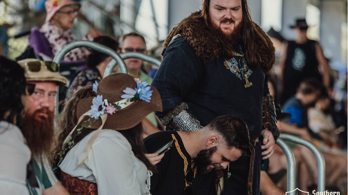 Viking crowd member in fur trim and armor interacting with crowds at Southern Realm Festival.
