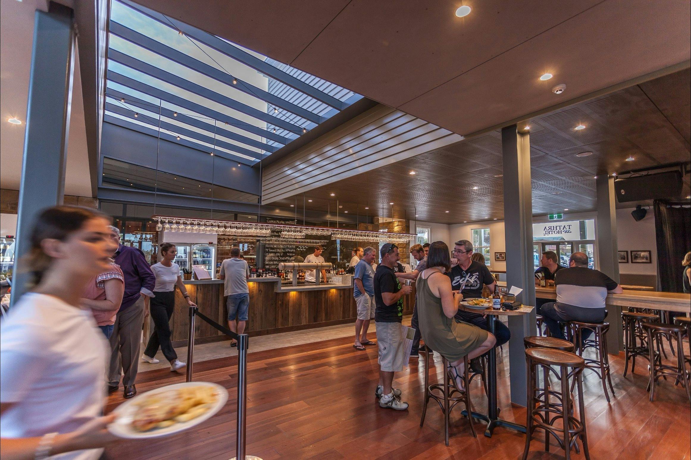 People are enjoying craft beers and wine at the Tathra Hotel