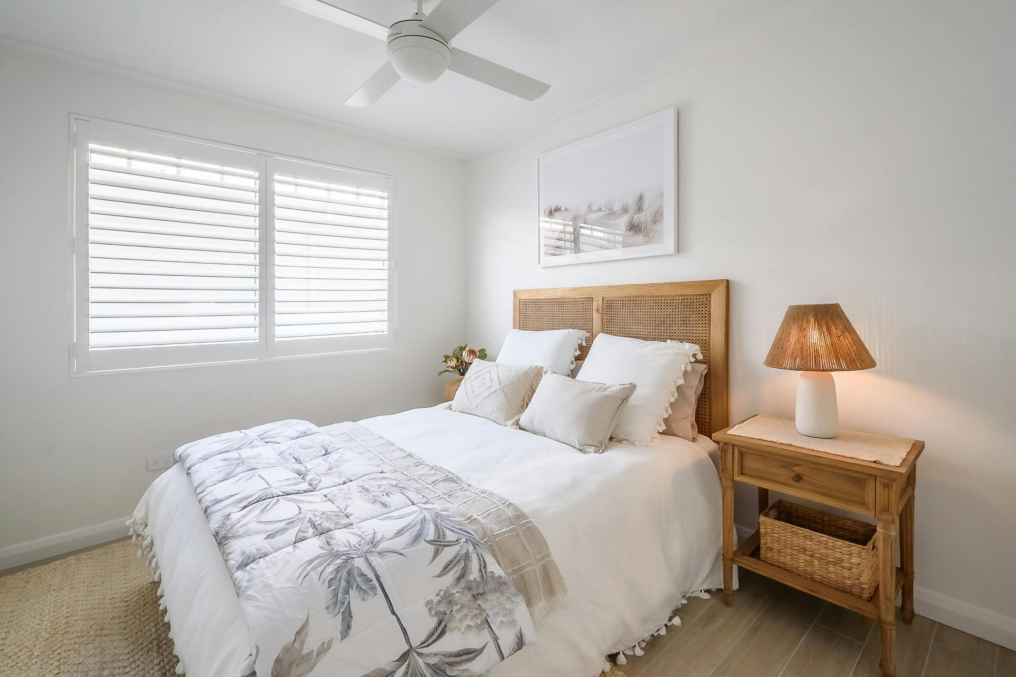 Bedroom with queen bed, bedside tables, lamp and ceiling fan