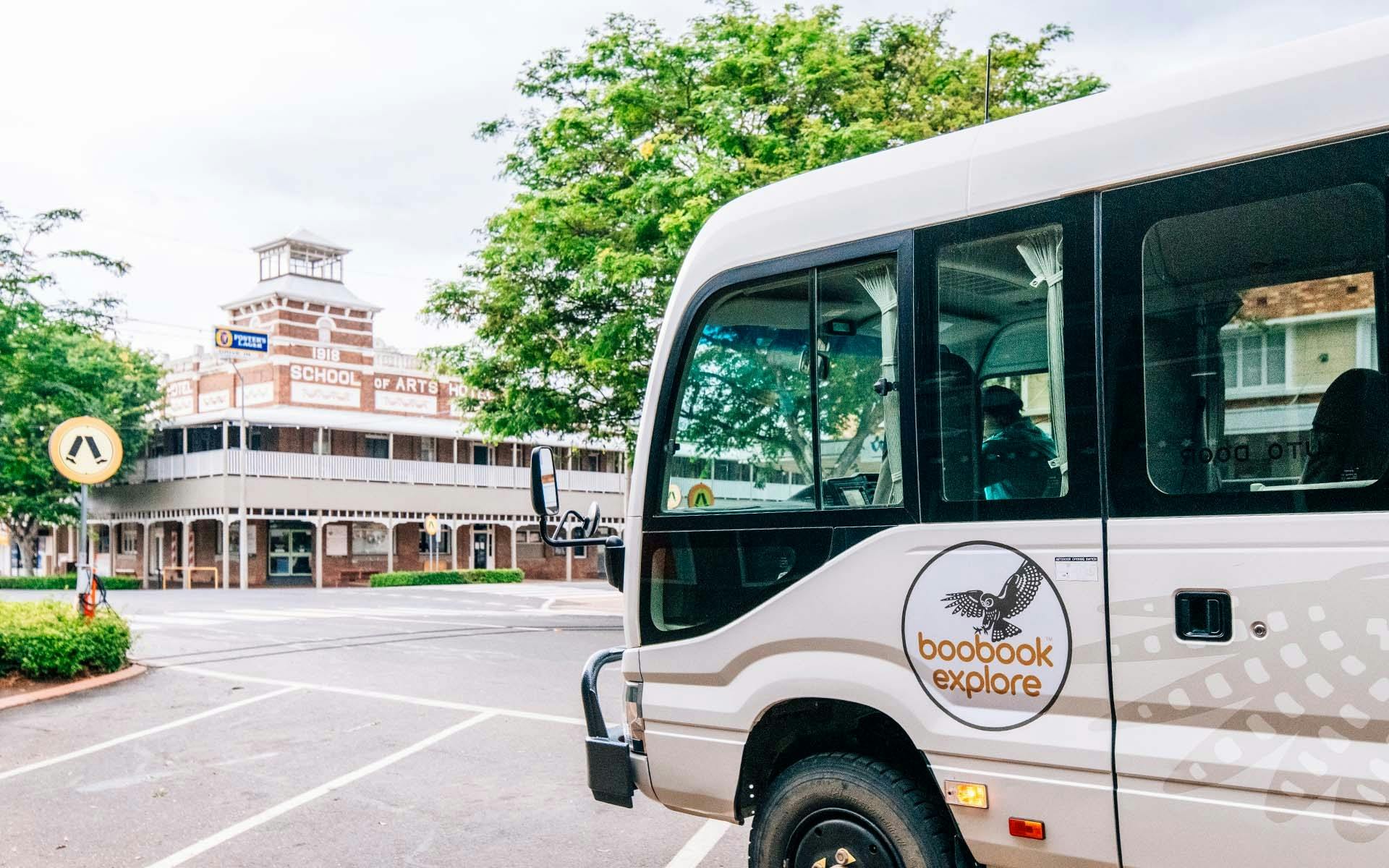 Boobook Explore's 4WD bus driving past Roma's School of Arts building