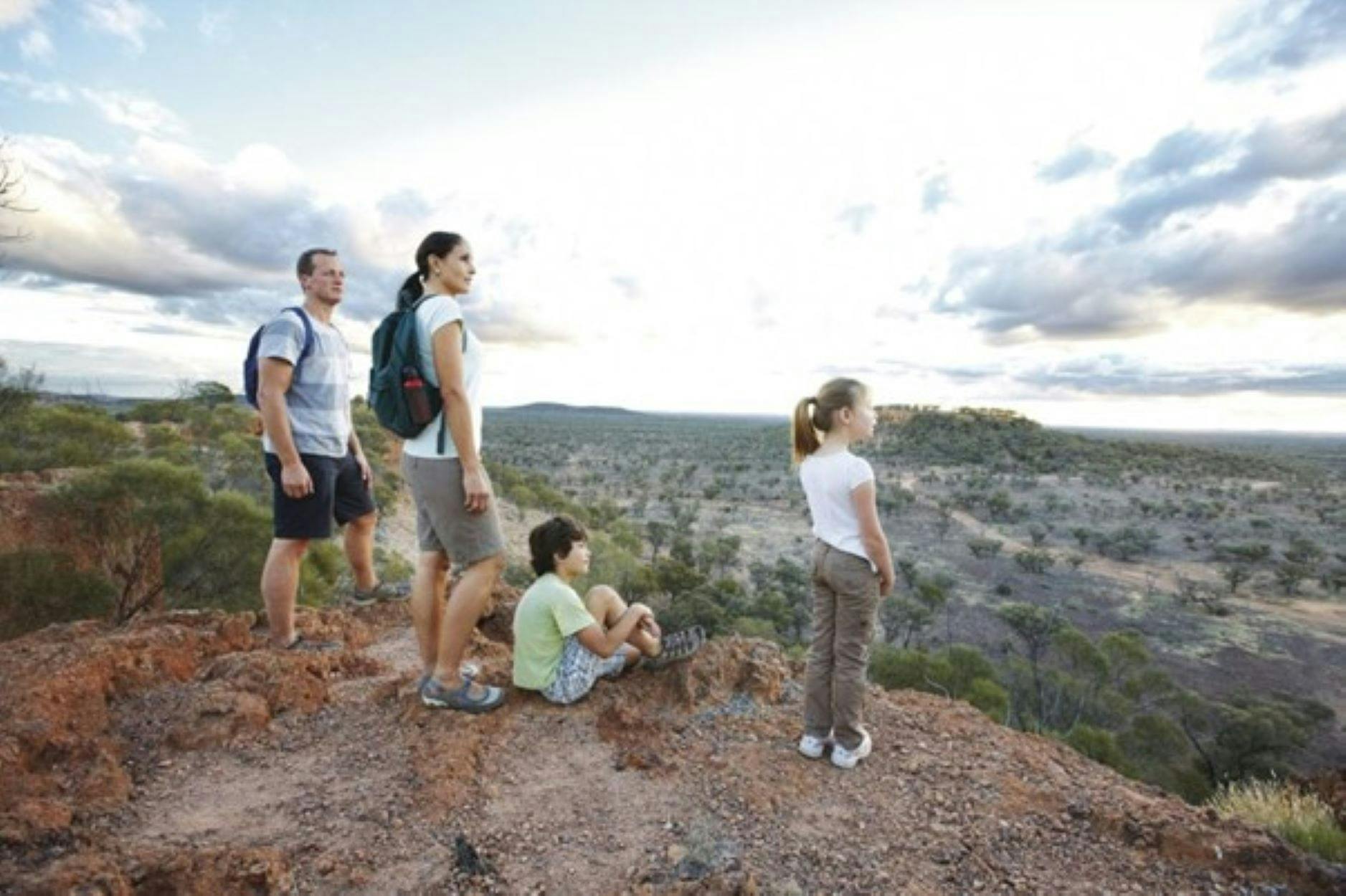 Man, Woman and Boy and Girl enjoy the view from Baldy Top, Quilpie