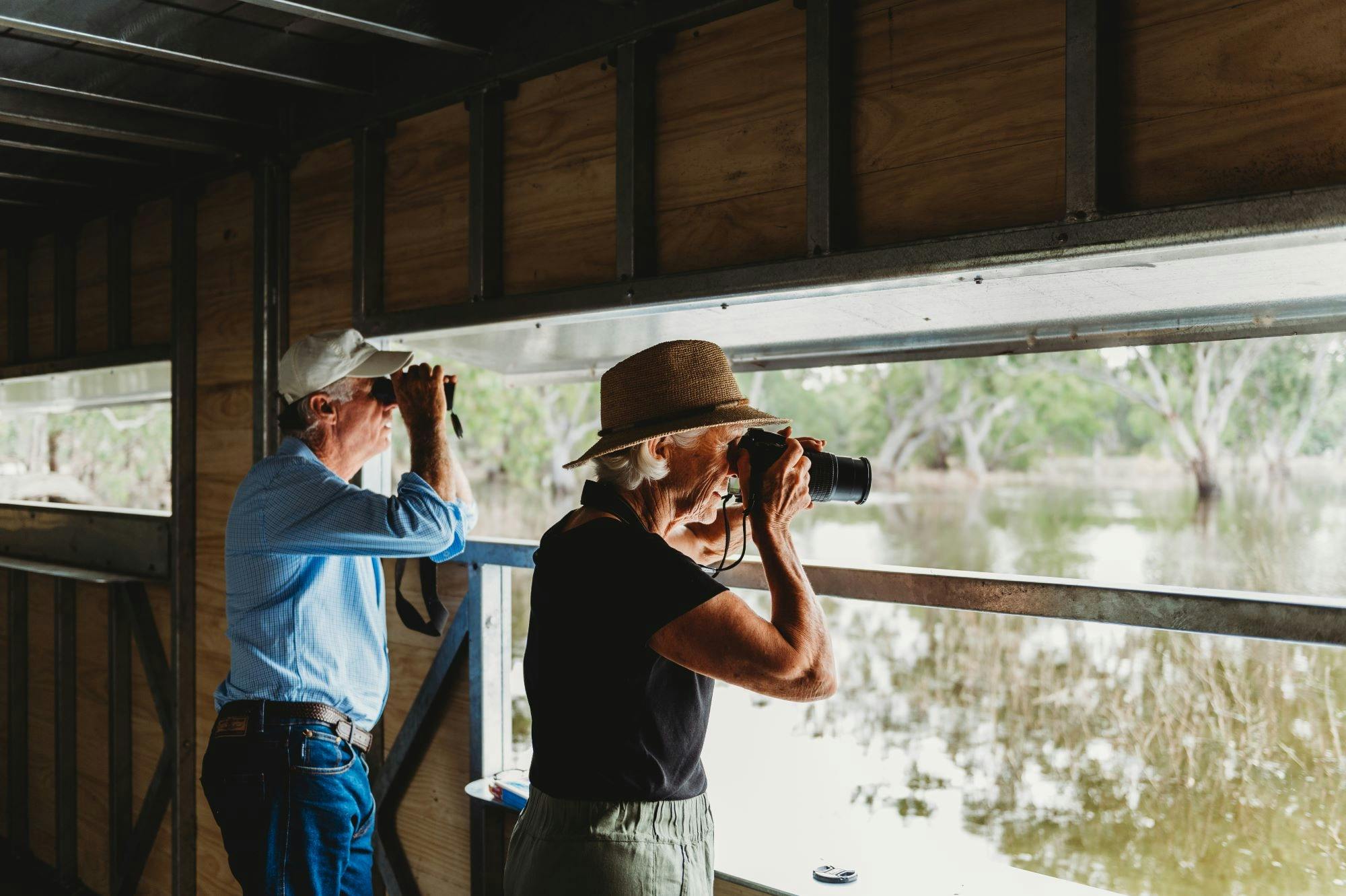 Man and woman bird watching from bird hide at Gum Swamp Wildlife Refuge