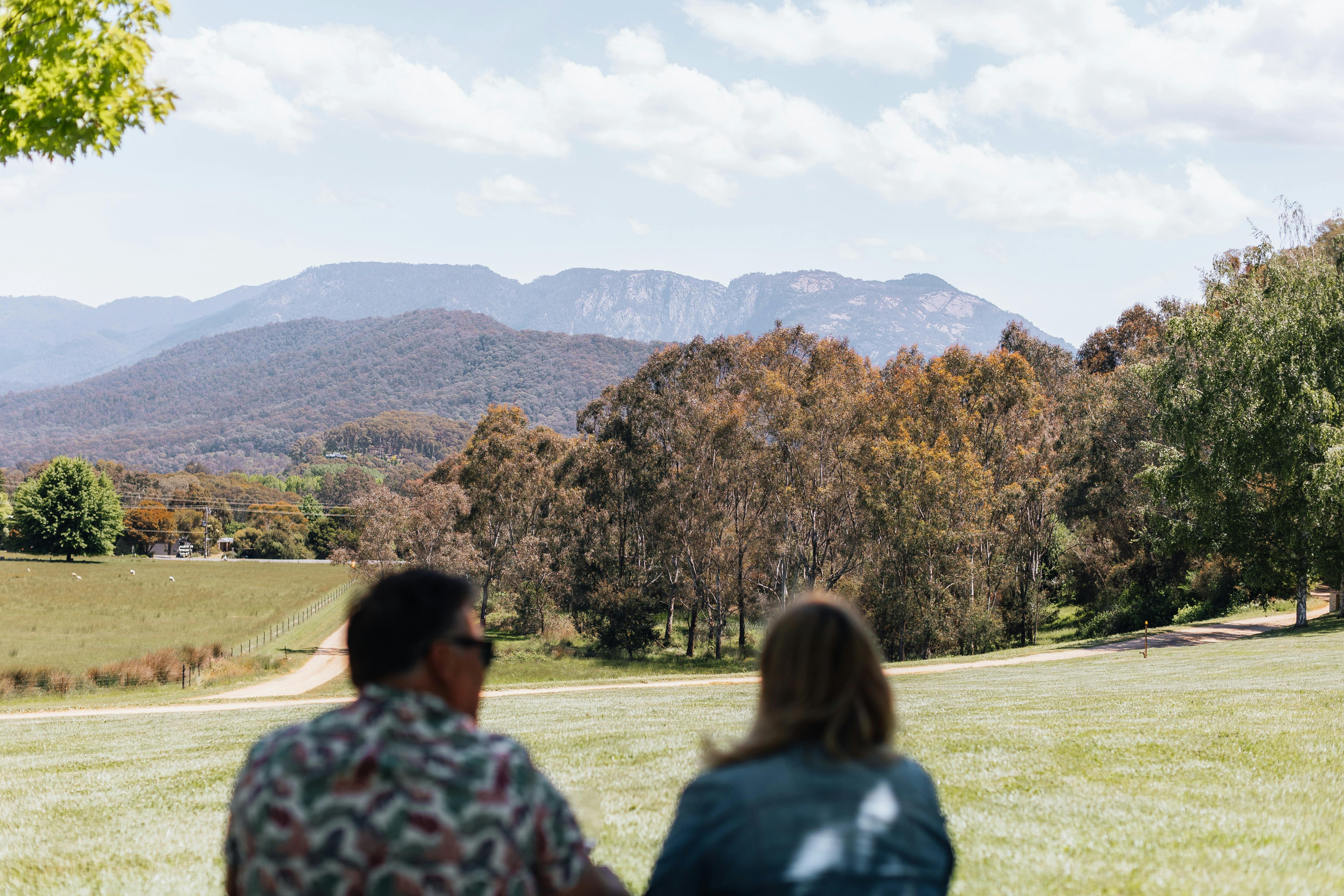 Couple looking at grass, trees and mountains at Ringer Reef winery