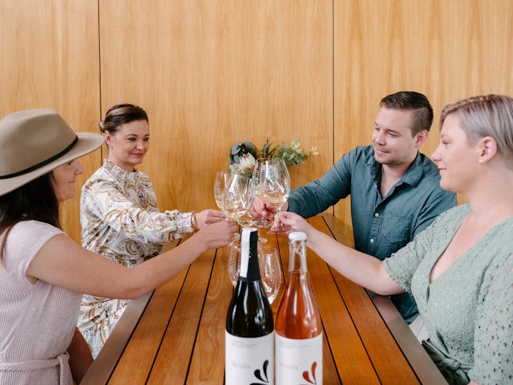 Cellar door guests cheers their wine glasses