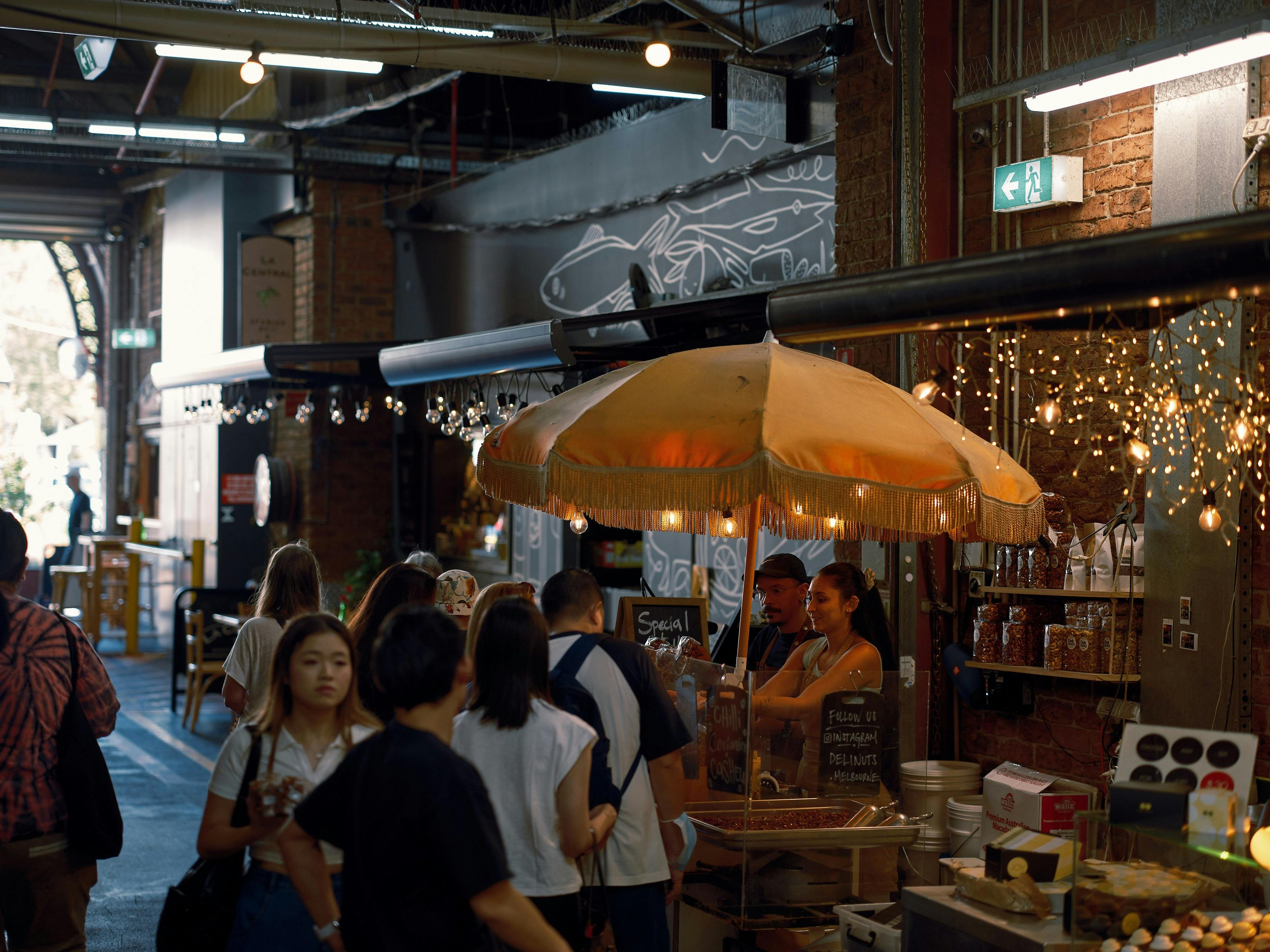 Customers queue at a busy Deli Nuts stall inside South Melbourne Market.