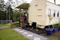 The Ghan train carriage, transformed into a luxury stay with a private deck and scenic countryside.