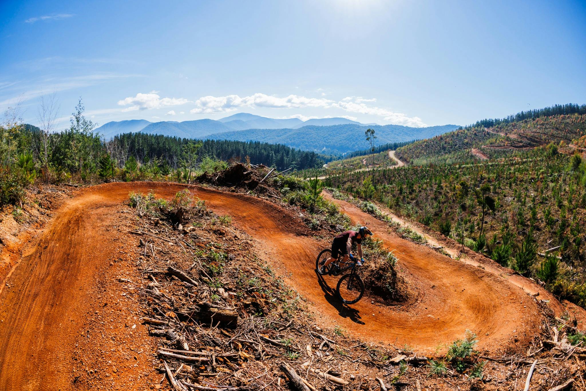 MTB cyclist on single track with mountain backdrop at Mystic Bike Park Bright
