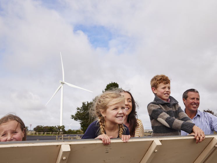 family looking with wind turbine in background