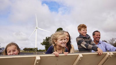 family looking with wind turbine in background