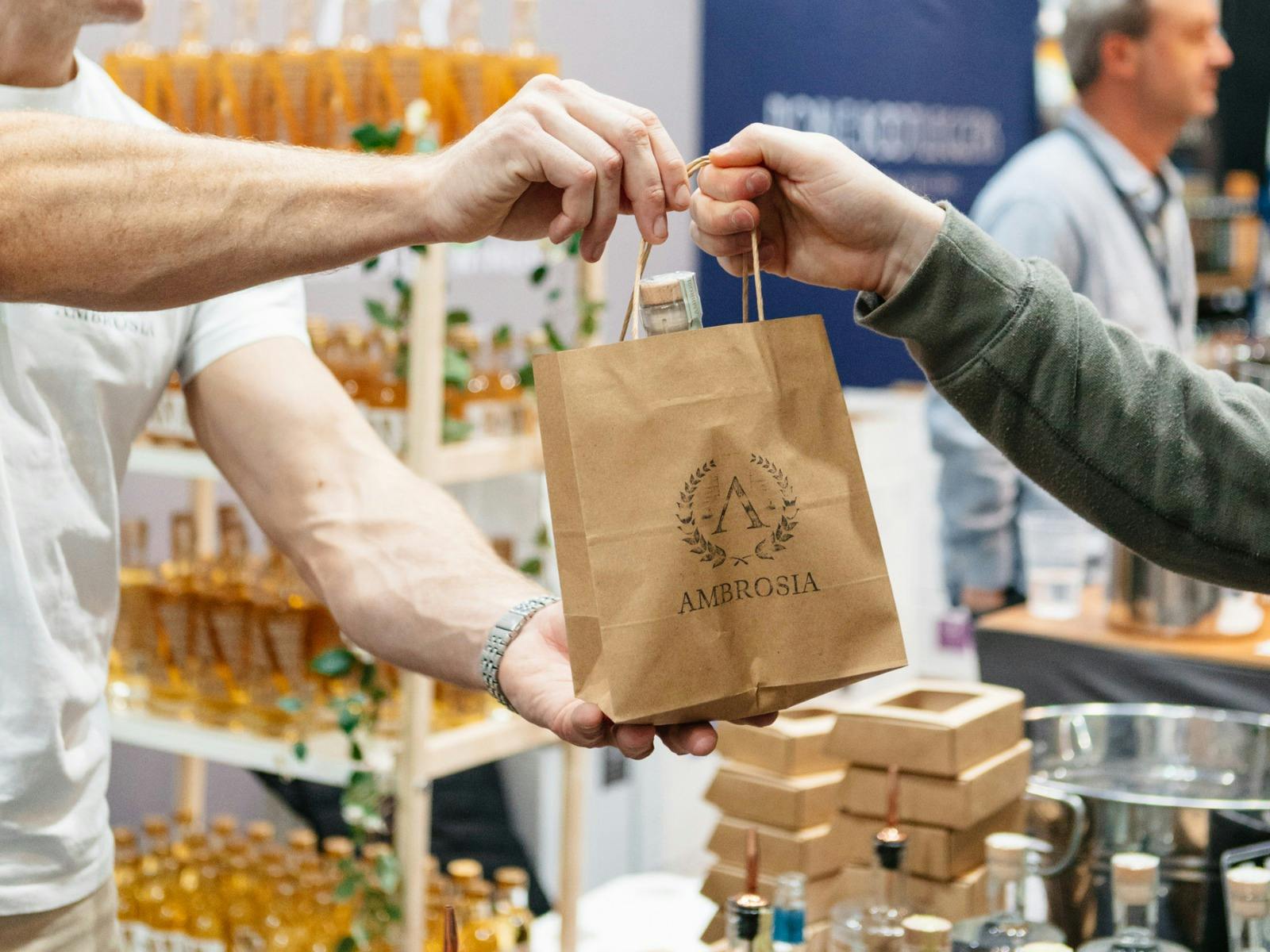 Ambrosia Distillery bag being handed to a customer