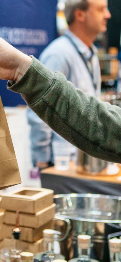 Ambrosia Distillery bag being handed to a customer