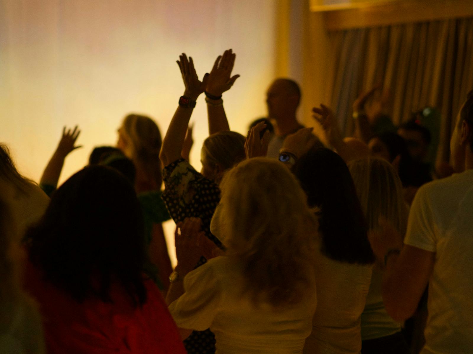 People dancing with hands raised
