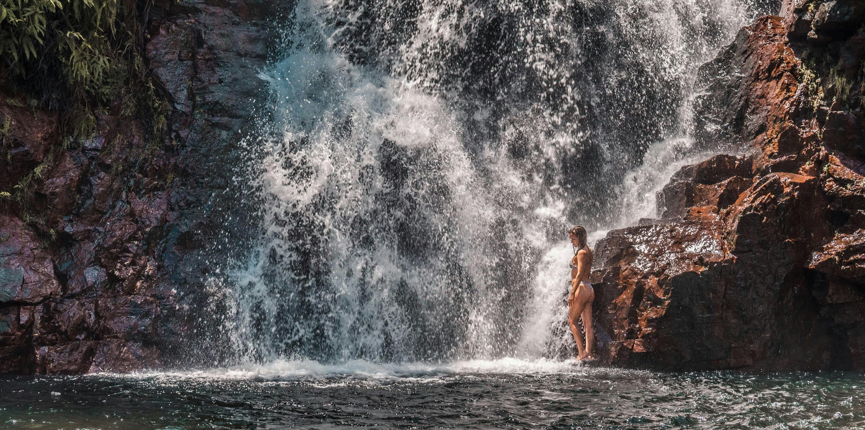 Girl at the bottom of a waterfall in Litchfield National Park