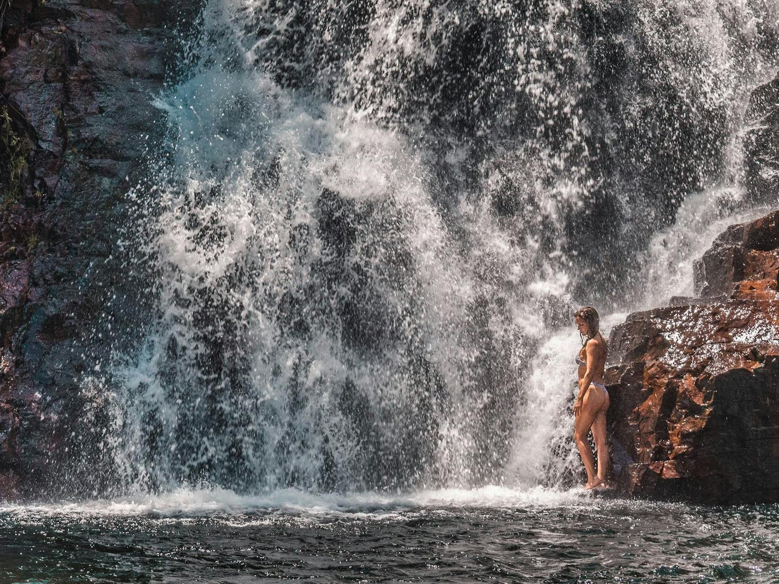 Girl at the bottom of a waterfall in Litchfield National Park