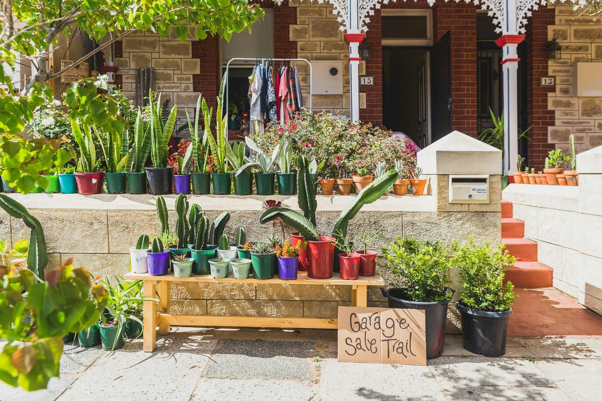 plants along wall with garage sale sign