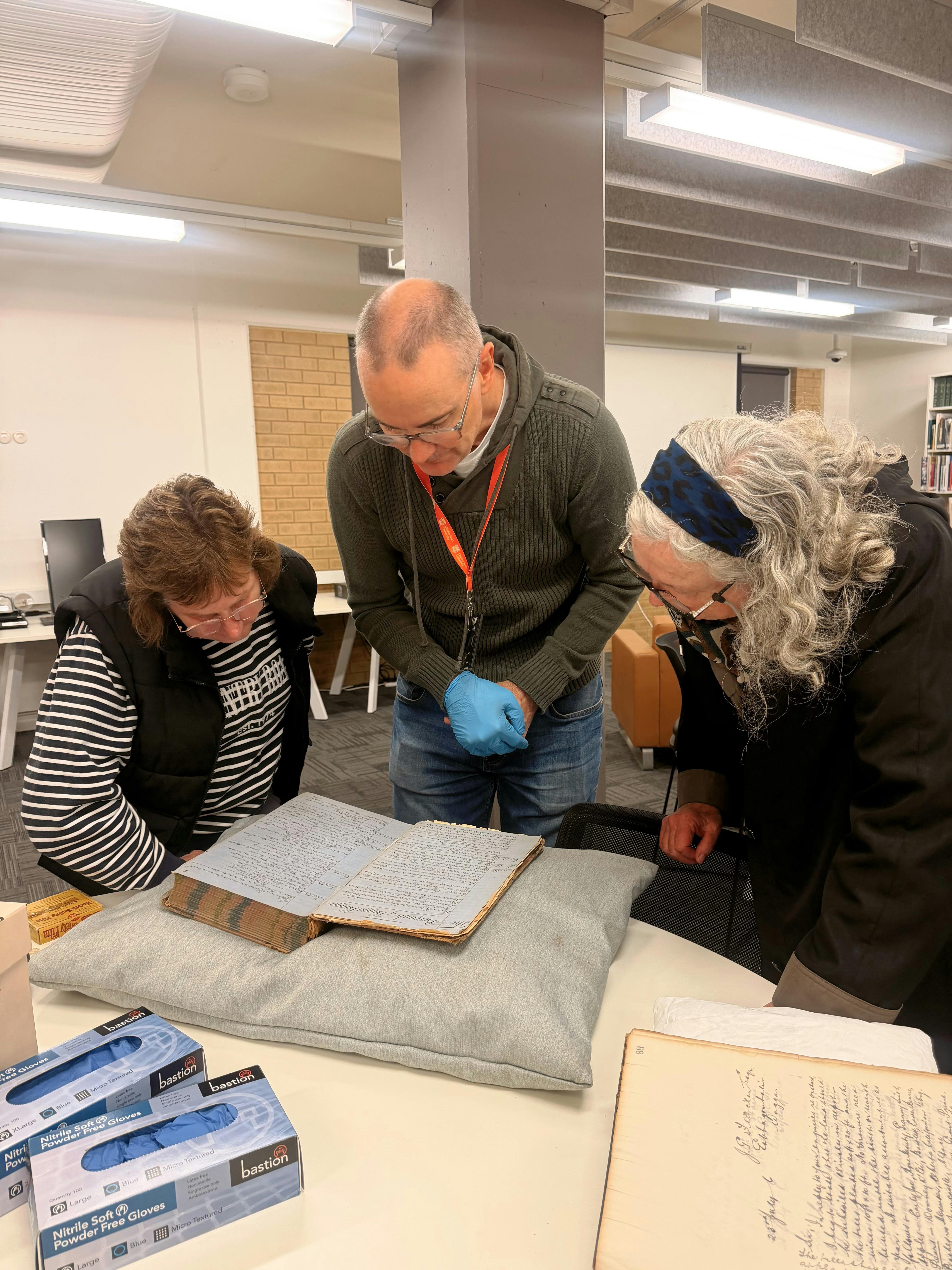 Two women look at the archives at Charles Sturt University