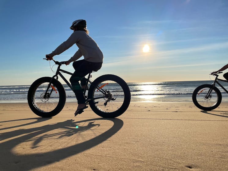 Person riding a fat bike on Culburra Beach