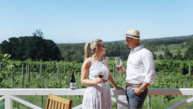 A couple enjoy a glass of wine on the Ashton Hills deck, overlooking the vineyards