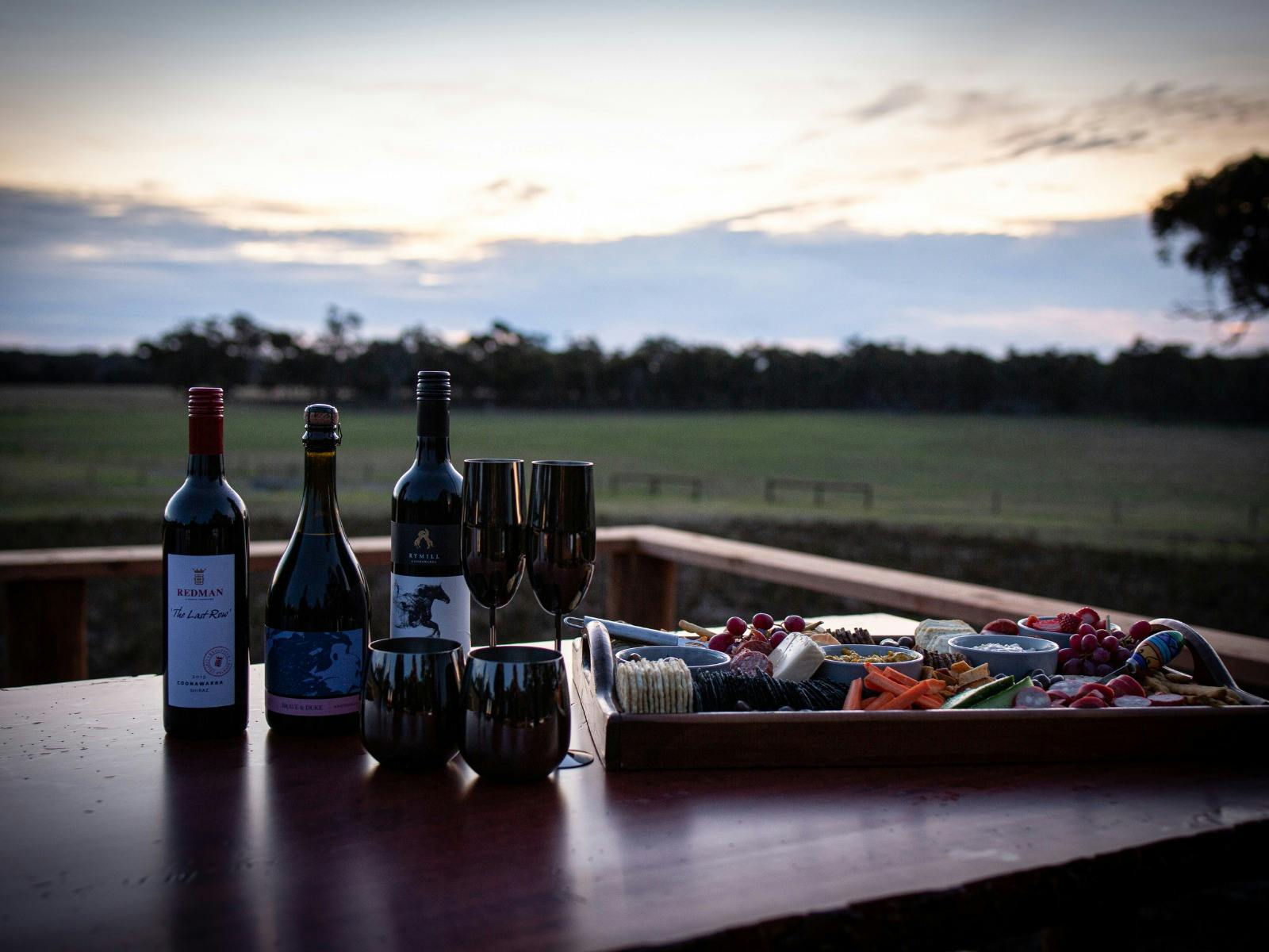 Local wine display with a food platter beside overlooking the farm in the background