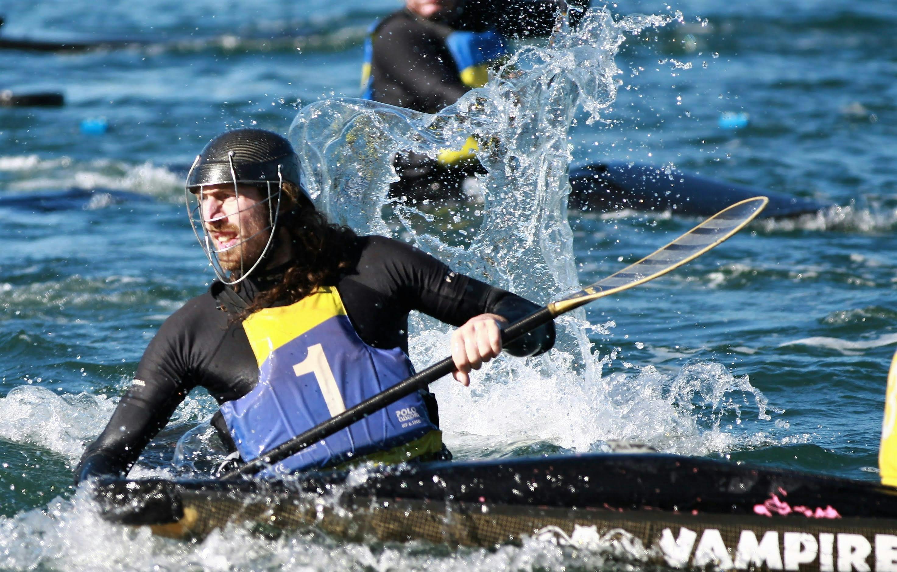 A single player is in the foreground, he is looking back whilst water splashes around him