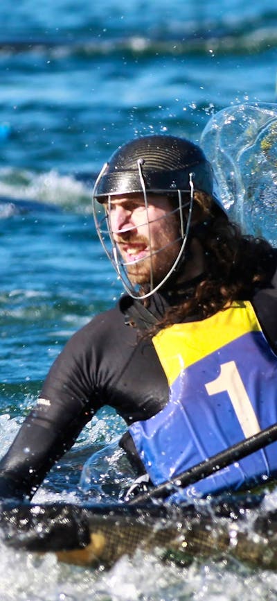 A single player is in the foreground, he is looking back whilst water splashes around him