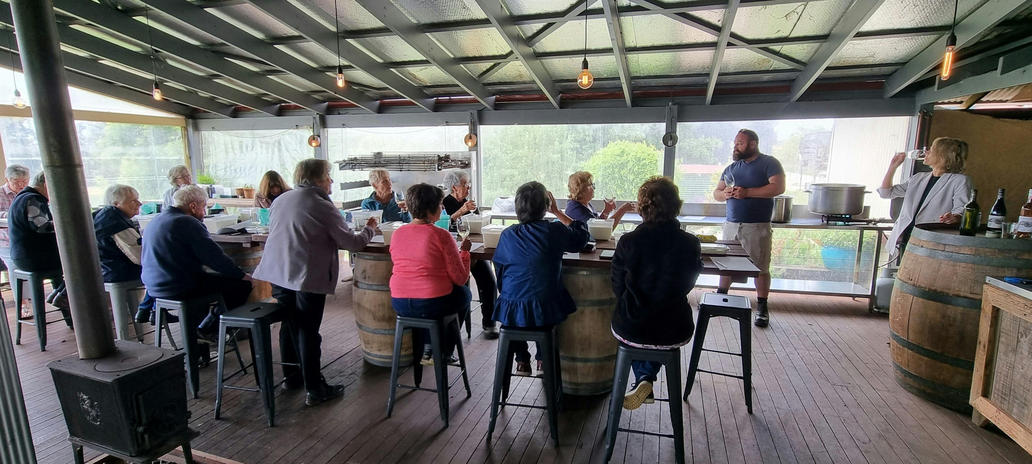A group participating in cheese making and wine pairing workshop