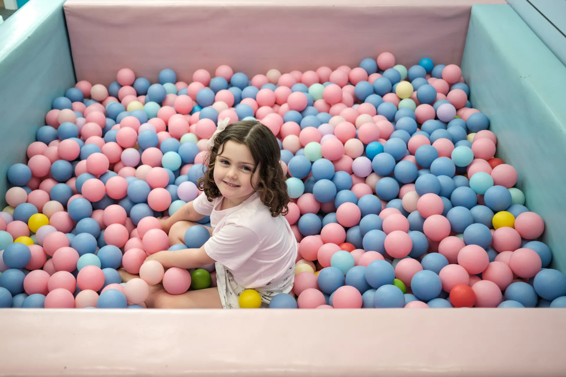 A visitor sitting in the ball pit