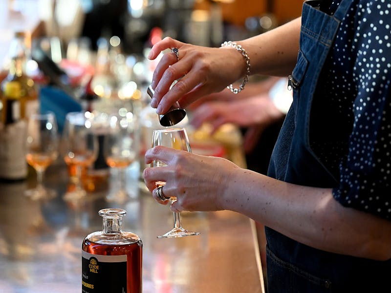 Bartender pouring Clyde Mill whisky into a tasting glass.