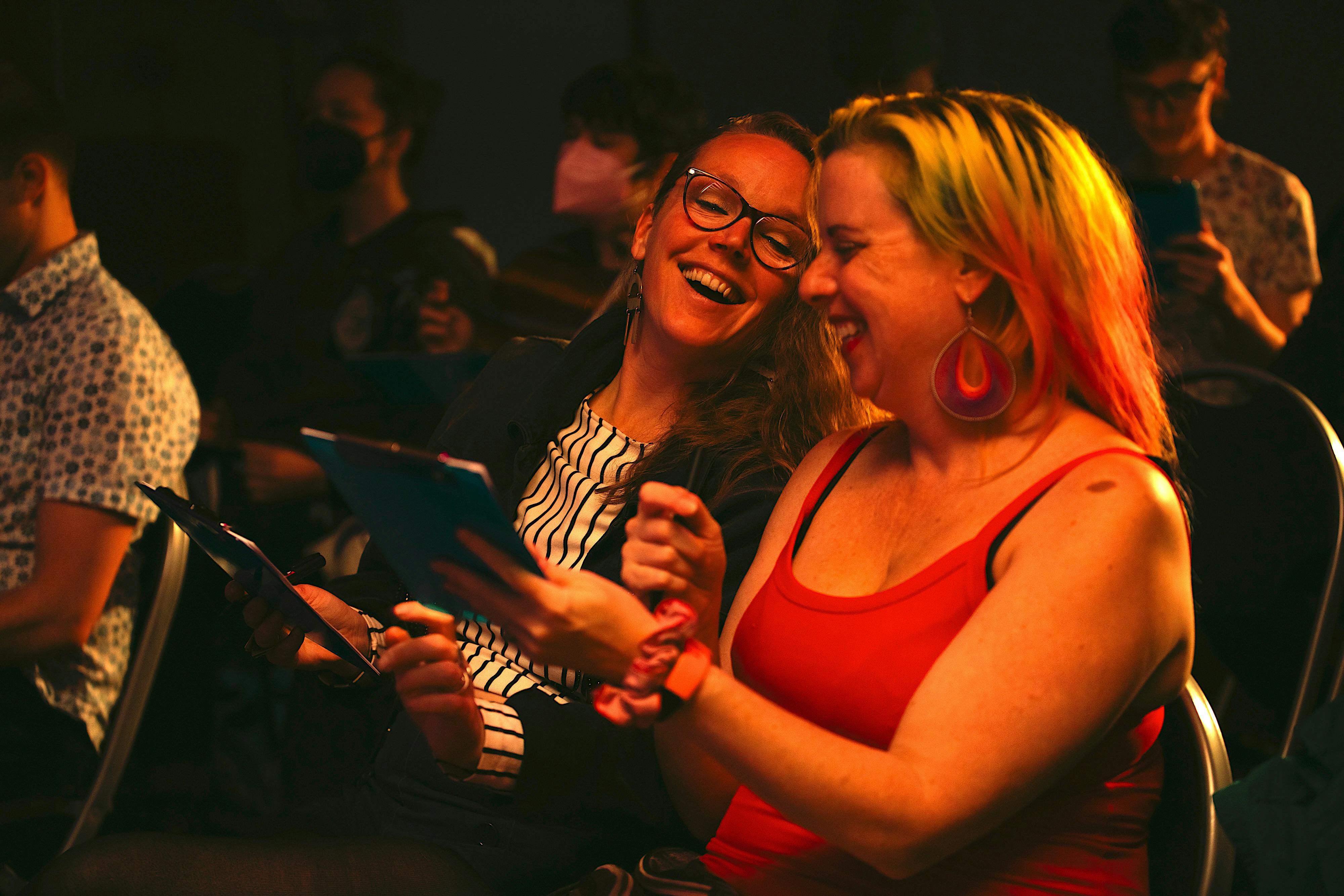 Two women are laughing over their drawings