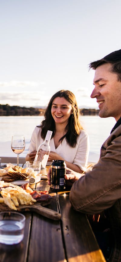 Four adults and a female child having a picnic on a boat
