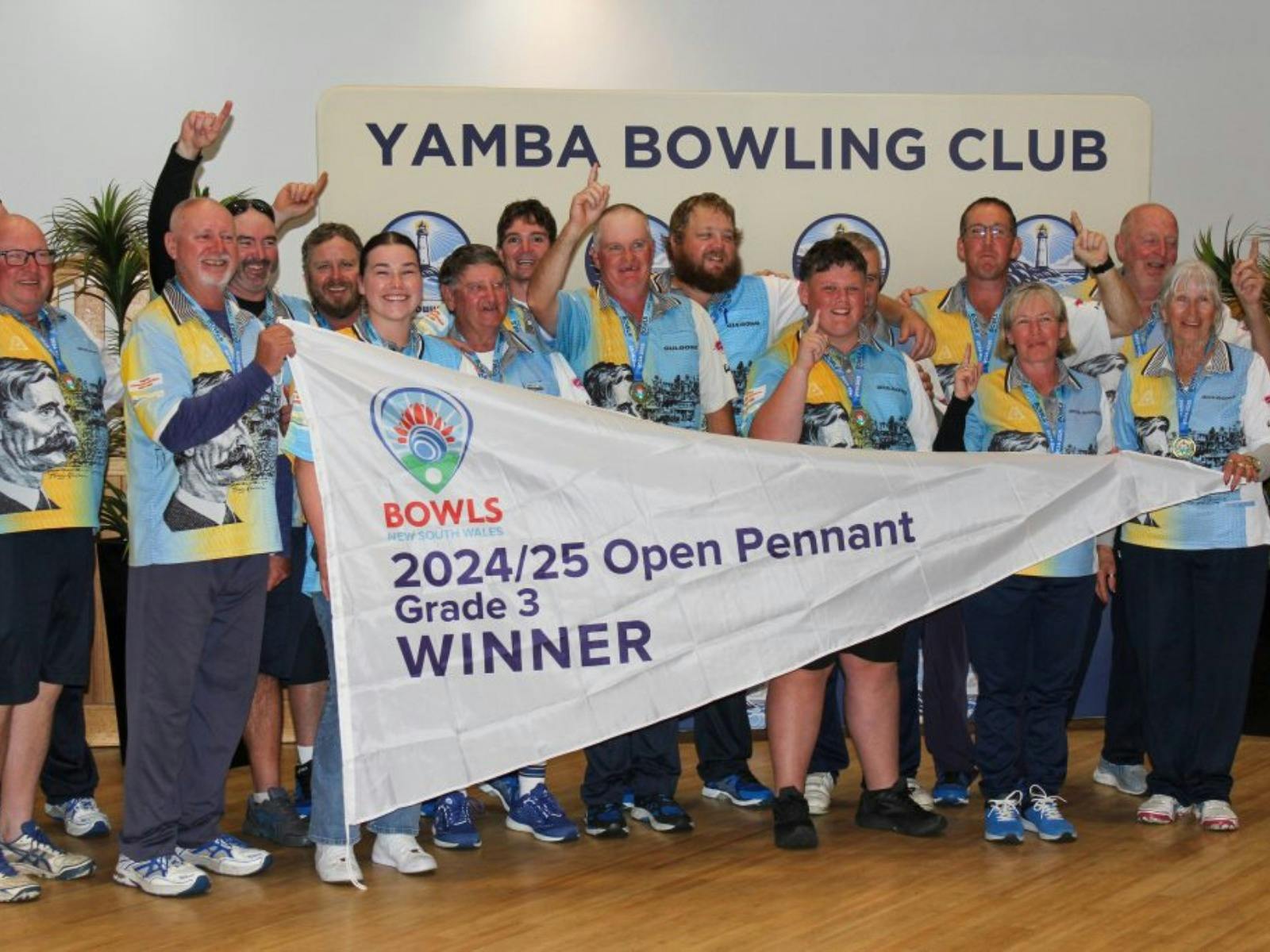 Bowls NSW Grade 3 Pennant winners celebrating with a victory banner