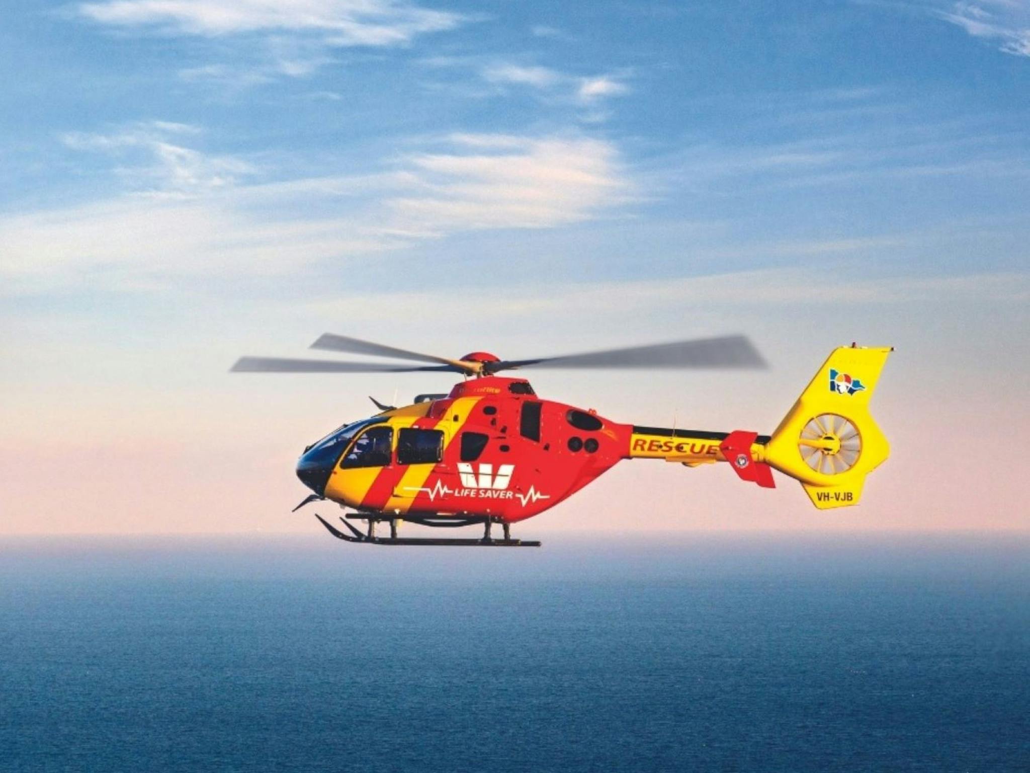 Image of a Westpac helicopter flying over the ocean enroute to a rescue