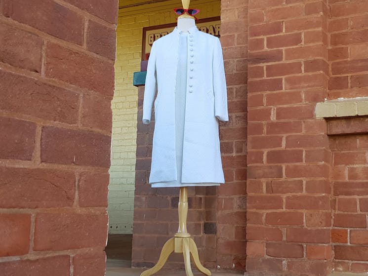Late 1960s white crimplene dress and coat set on mannequin at top of Cobar museum stairs.