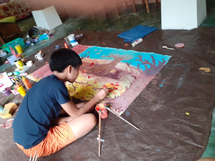 Child working on an autumn themed painting