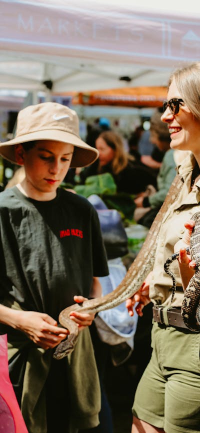 Emma from Canberra Snake Rescue holding a python at the Haig Park Village Markets