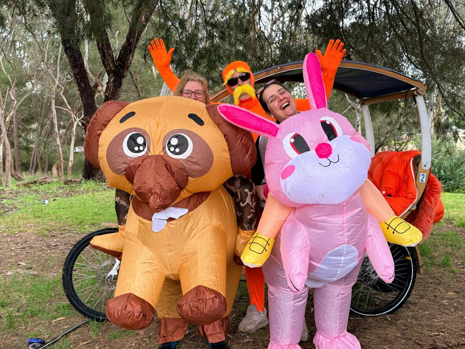 2 inflatable costume wearing adults with a lorax and a tuktuk in the background on the Shiraz Trail