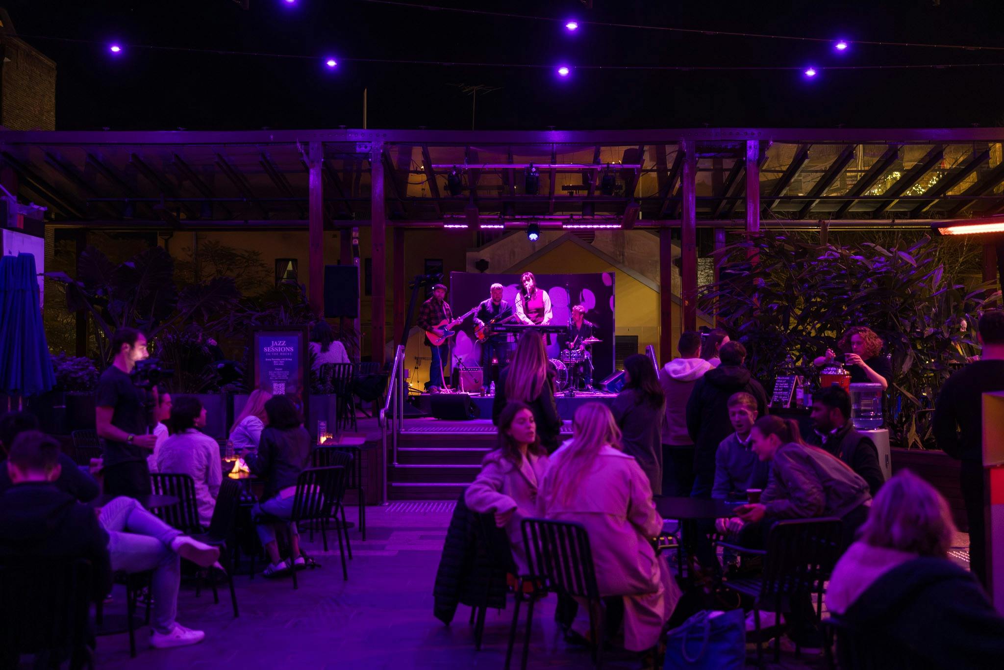 People enjoying live music with soft purple lighting