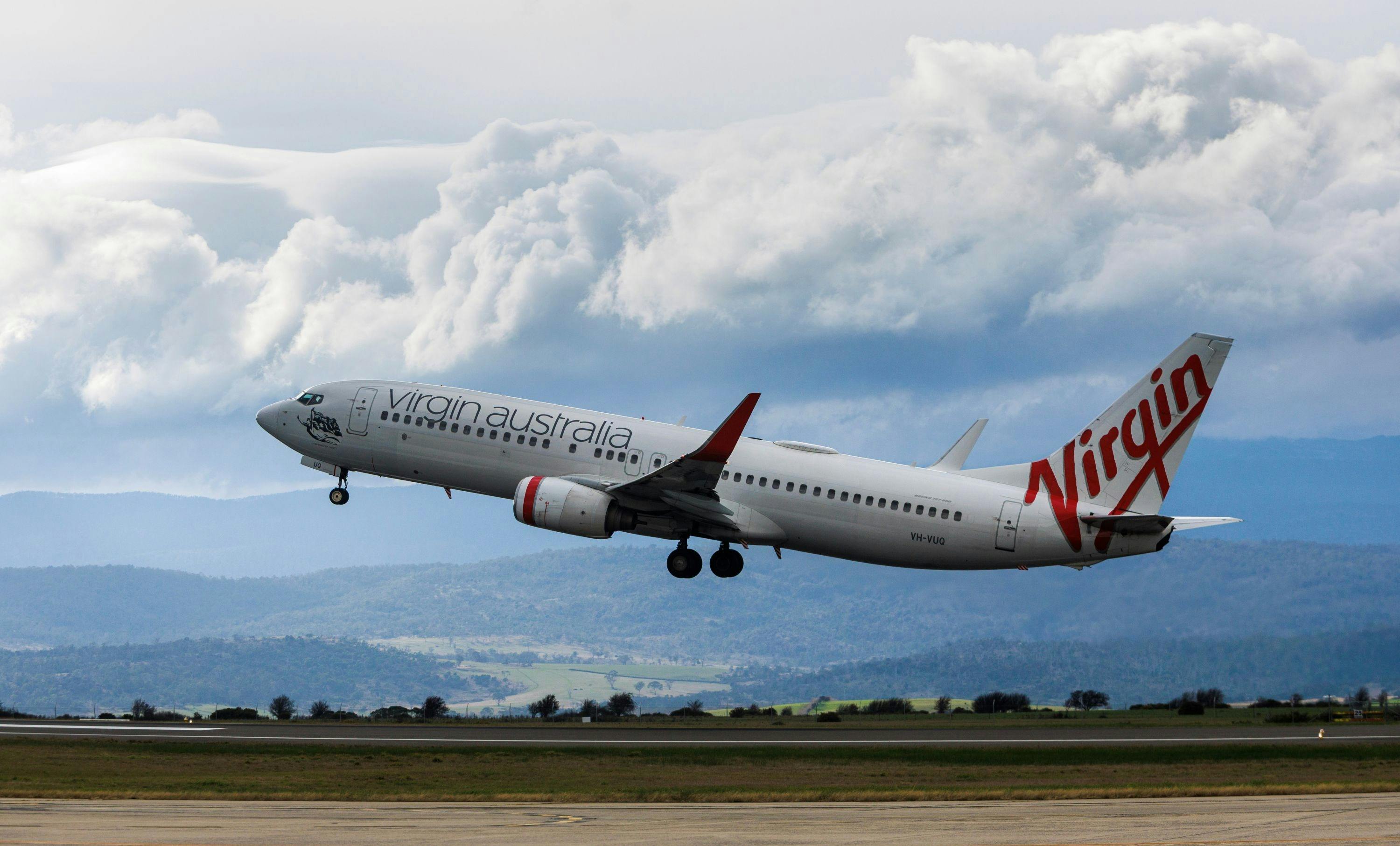 Virgin Airways aircraft taking off with Ben Lomond backdrop
