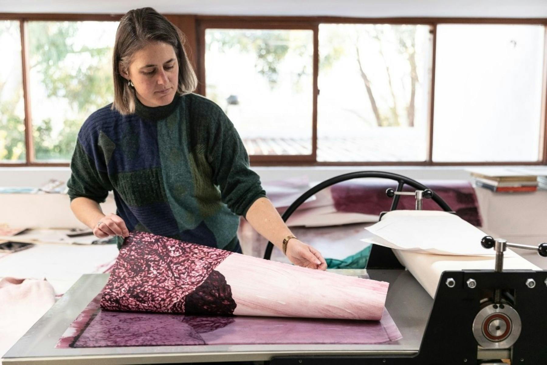 Annika Romeyn pulling a section of her watercolour monotype 'Old Mutawintji Gorge 2,'