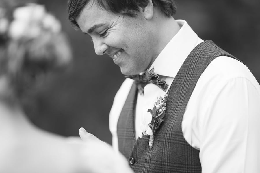 A happy groom smiles during his wedding ceremony