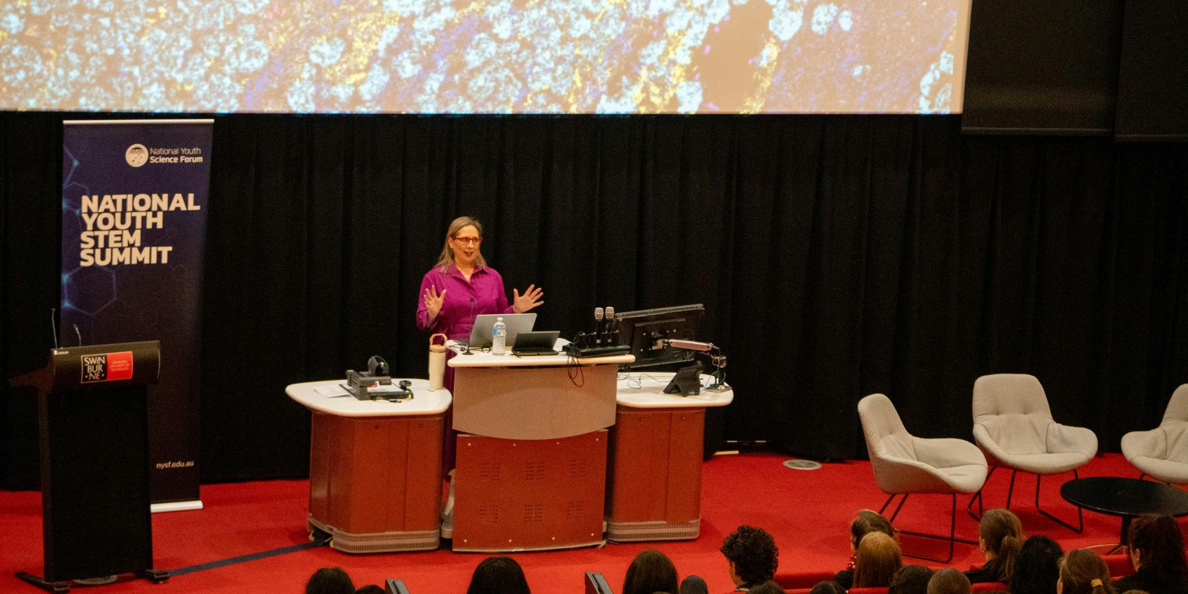 Professor Misty Jenkins giving a lecture at a podium in a lecture theatre