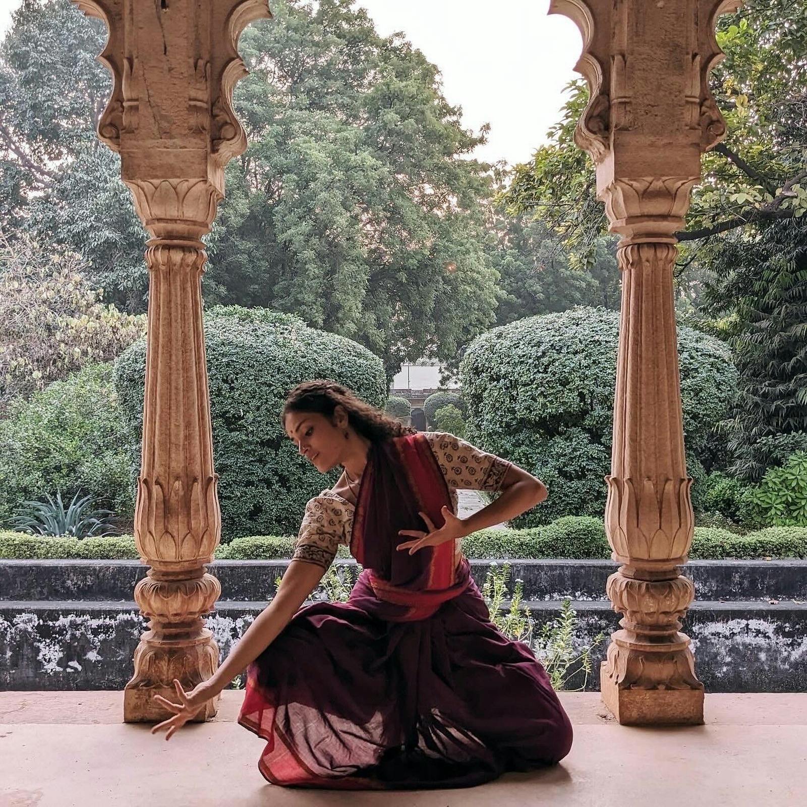 Woman in sari kneeling in temple