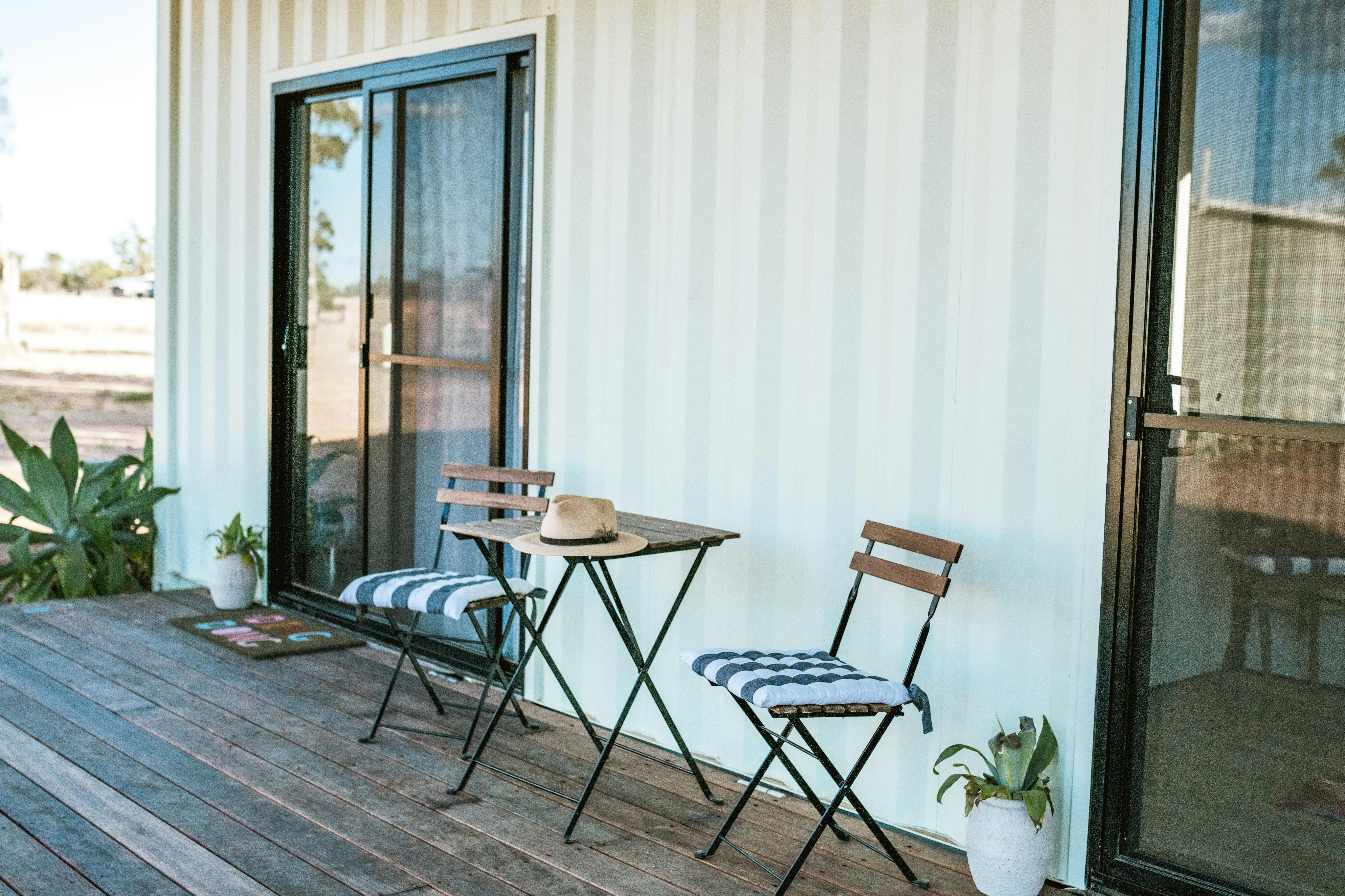 A cabin accommodation at Gilgooma farm stay with plants and seating on the outdoor deck with a view
