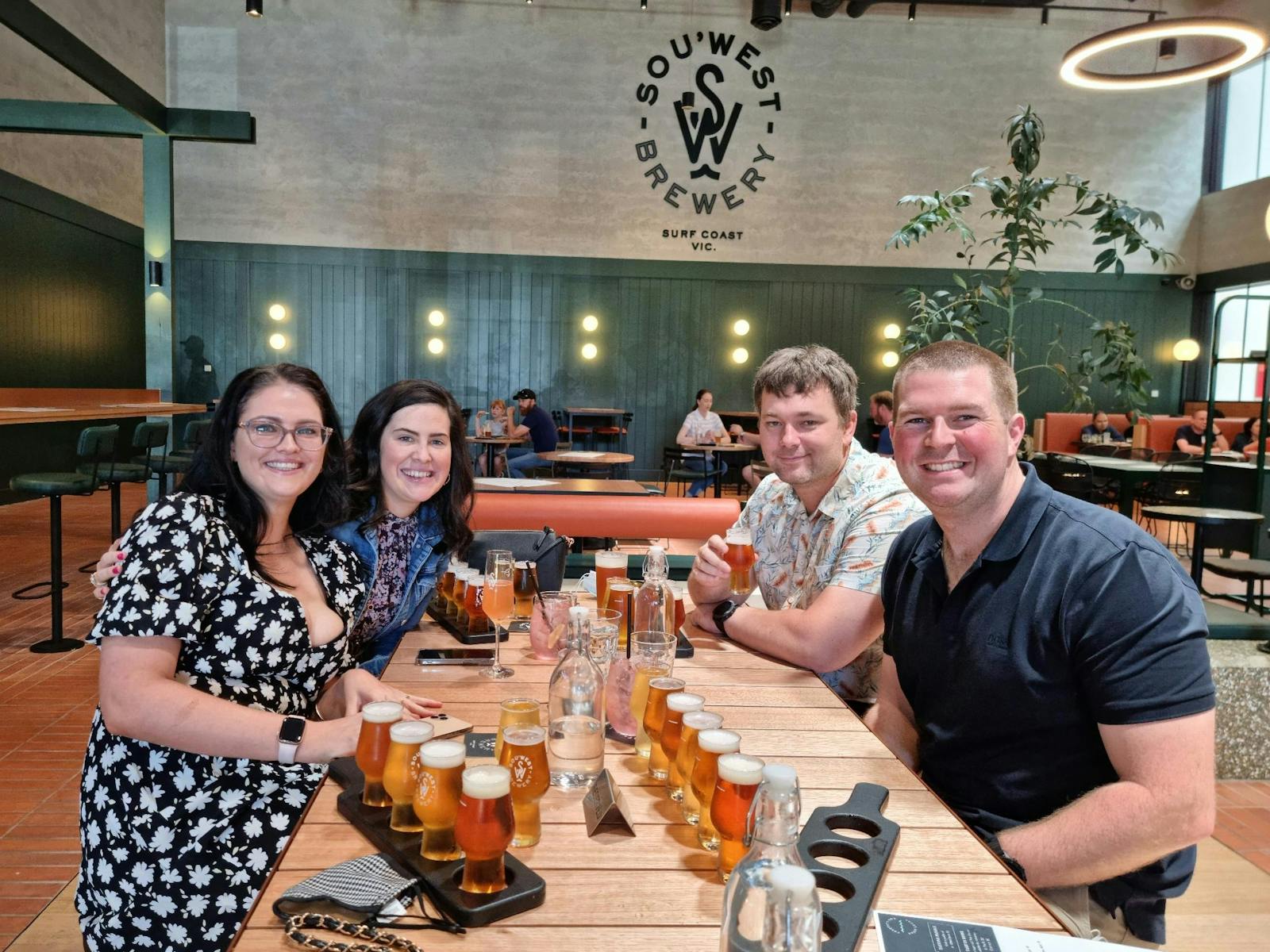 Four guest with beer paddles at SouWest Brewery