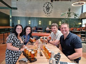 Four guest with beer paddles at SouWest Brewery